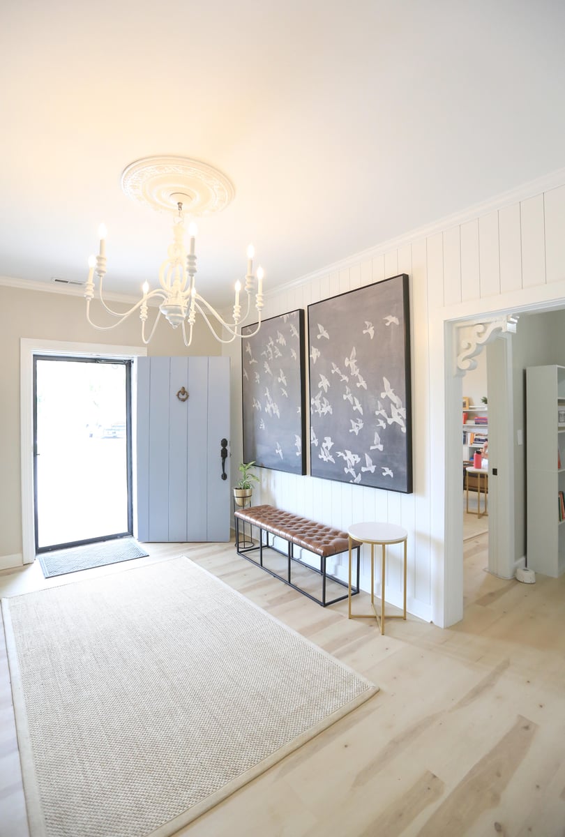 TN Mental Wellness inside office view showing white chandelier with two large paintings of white birds flying on the wall and bench underneath in big spacious room